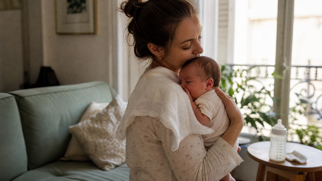 Maman qui garde son bébé droit contre son épaule après la tétée pour limiter les régurgitations
